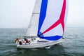 A sailboat flying a Cruising Asymmetrical Spinnaker in blue, white, and red colors.